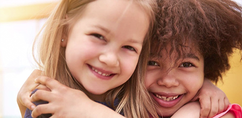 Two children hugging each other and smiling