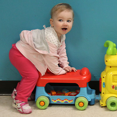 photo of older infant playing on alphabet train toy